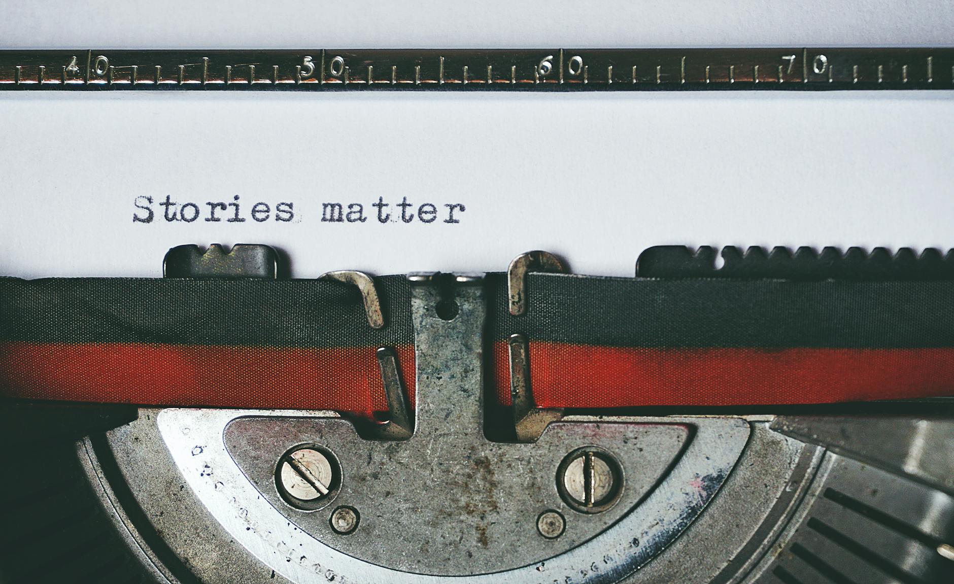 A close-up of a typewriter showing the words 'Stories matter' typed on a sheet of paper.